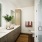 bathroom with dual sinks and backlit mirrors