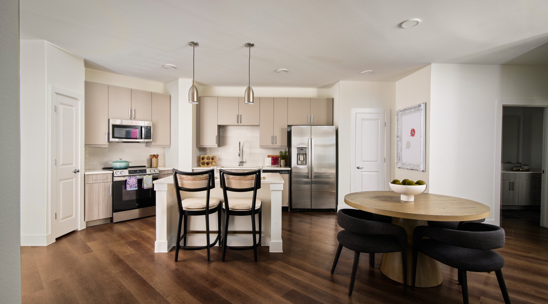 Wide open living areas flooded with natural light kitchen with bar stools and a table with seating