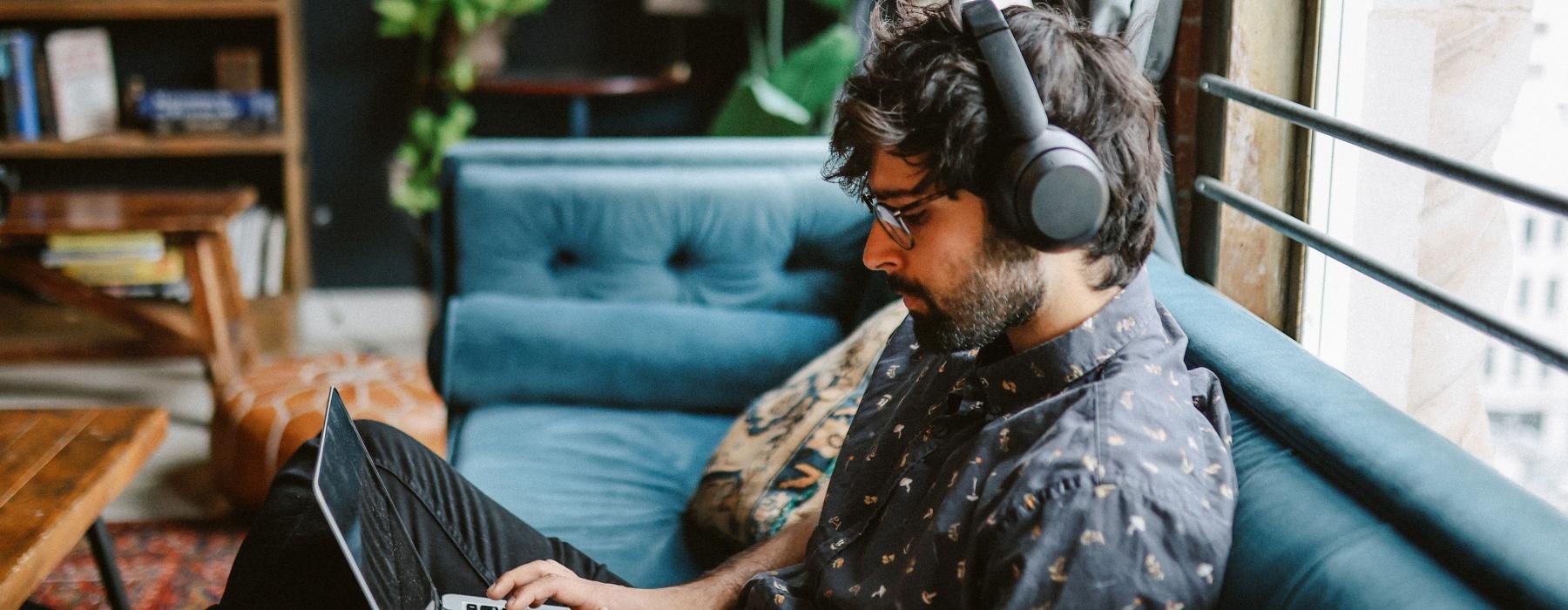 a man wearing headphones and using a laptop